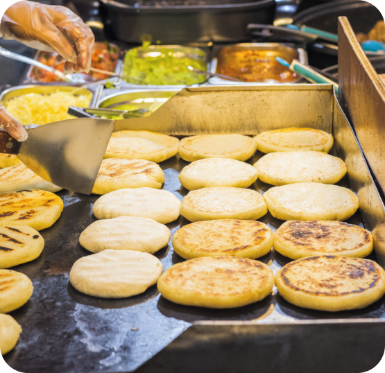 Food preparation station displaying sandwich buns and fresh ingredients in a fast casual restaurant environment.